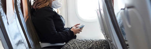 woman with cellphone on a plane that has lithium-ion battery