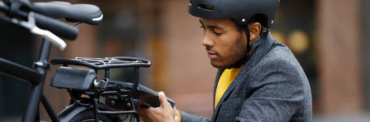 Young man changing battery pack on electric bicycle