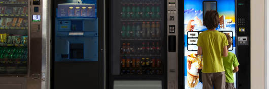 Children standing in front of a refrigerated vending machine