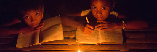 Children studying by kerosene lantern