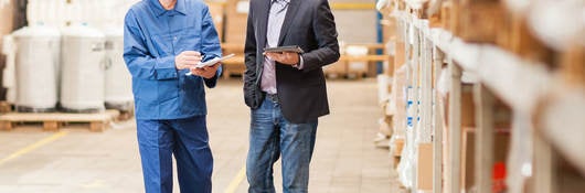 Men wearing hardhats in warehouse talking