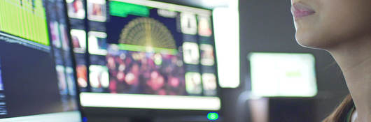 Close up image of a young Asian woman with monitors