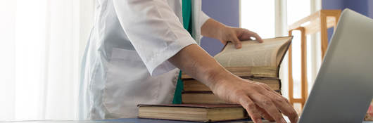 A medical professional’s hand, using laptop computer 