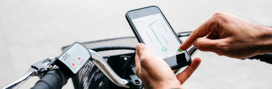 Man with e-bike using a smartphone for navigation