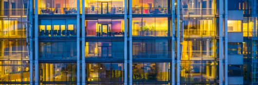 Business office building windows illuminated at dusk