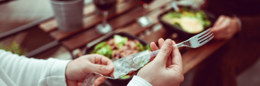 Person taking plastic fork out of a package