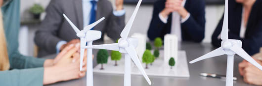 Scale models of wind turbines on a desk during a planning meeting