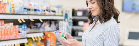 Brunette woman looking at product labels in a store