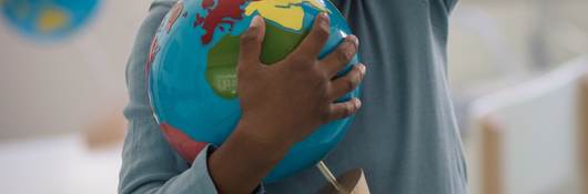 Child holding a toy ball.