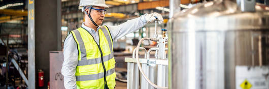 Worker operating a gas tank in a factory