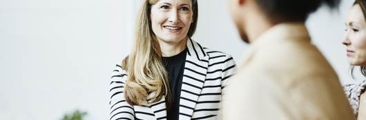 Smiling businesswoman shaking hands with client