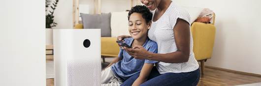 African American woman and her son setting up the intelligent home system on a smartphone.