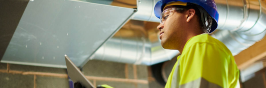 HVAC worker inspecting ceiling panel