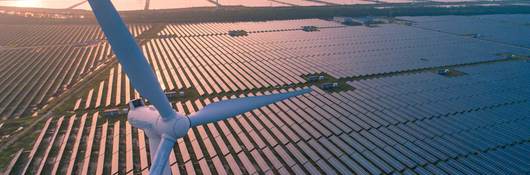 Wind turbines over a solar panel field