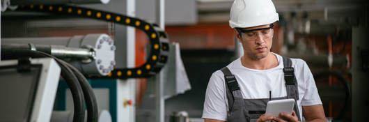 Worker in hardhat working with a tablet