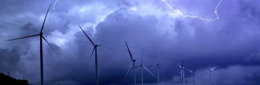 Lightning Over Wind Turbines Against Sky 