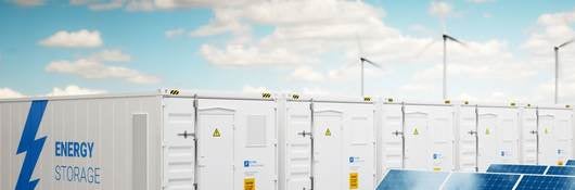 Energy storage cabinets with wind turbines and solar panels with blue sky and light clouds