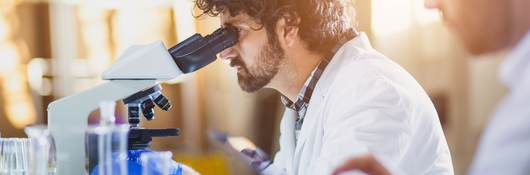 Scientist looking through a microscope