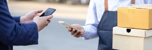 A man instantly pays delivery man with mobile phone