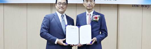 Image of two people holding certificate at signing ceremony