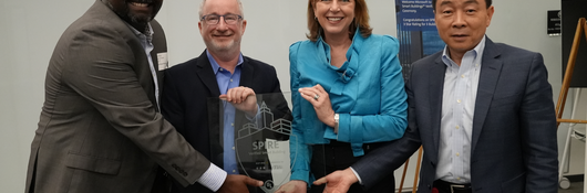 Microsoft and UL leadership hold a glass SPIRE Rating plaque