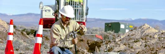 Worker installing cables for underground distribution.