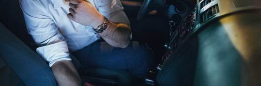 Man using laptop in a car