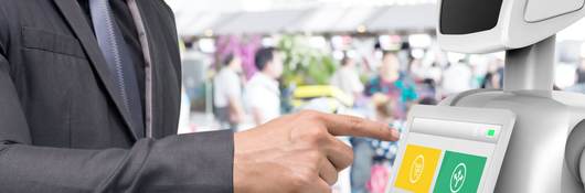 Businessman using autonomous personal assistant robot for navigation at the airport