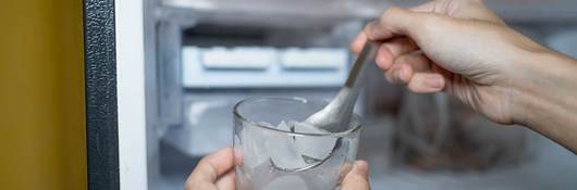 Filling up a glass with ice from freezer