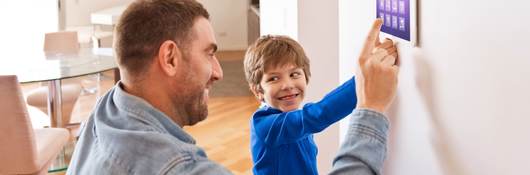 Father and his child are touching a IoT device.