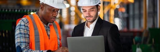 Two engineers looking at a laptop