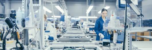 Shot of an Electronics Factory Workers Assembling Circuit Boards by Hand While it Stands on the Assembly Line. High Tech Factory Facility.