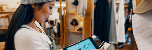 Retail shop clerk taking a mobile credit card payment on a digital tablet