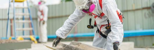 An employee follows the correct safety procedure while handling asbestos. 