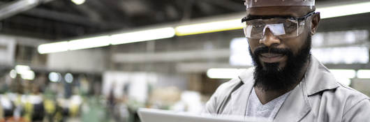 Man working with a digital tablet in a factory