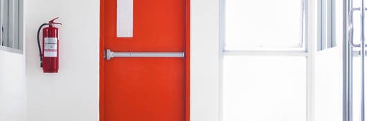 Red emergency fire door with labels