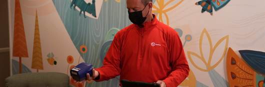 UL Solutions employee in red shirt tests air Ronald McDonald House. 