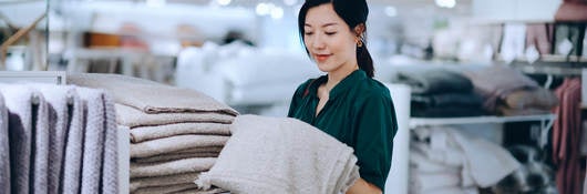 Asian woman shopping for bath towel