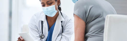 Doctor and patient looking at a tablet in an office. 