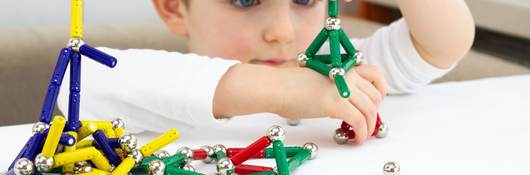 Boy playing with a toy magnets.