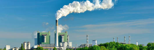 Steaming ignite-fired power plant in a green landscape