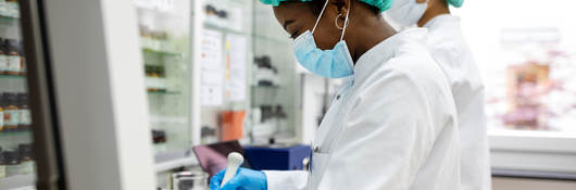 Two chemists working while wearing PPE