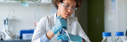 person using a dropper in a laboratory