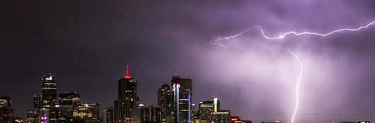 A lightning storm behind a city 