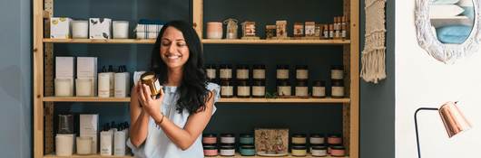 Stylish woman shopping in fragrance and beauty section of home store.