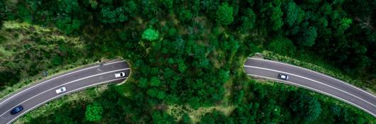 Aerial view of green bridge corridor for wildlife to cross highway safely.