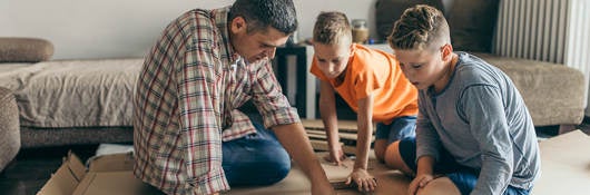 Father is assembling furniture with his kids.