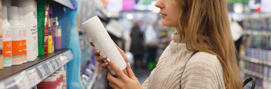 Person reading a label on a product while shopping in a store