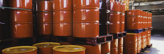 Stacks of red oil barrels in a warehouse