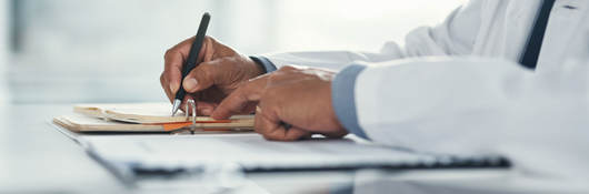 Close up of a doctor writing notes on paper 